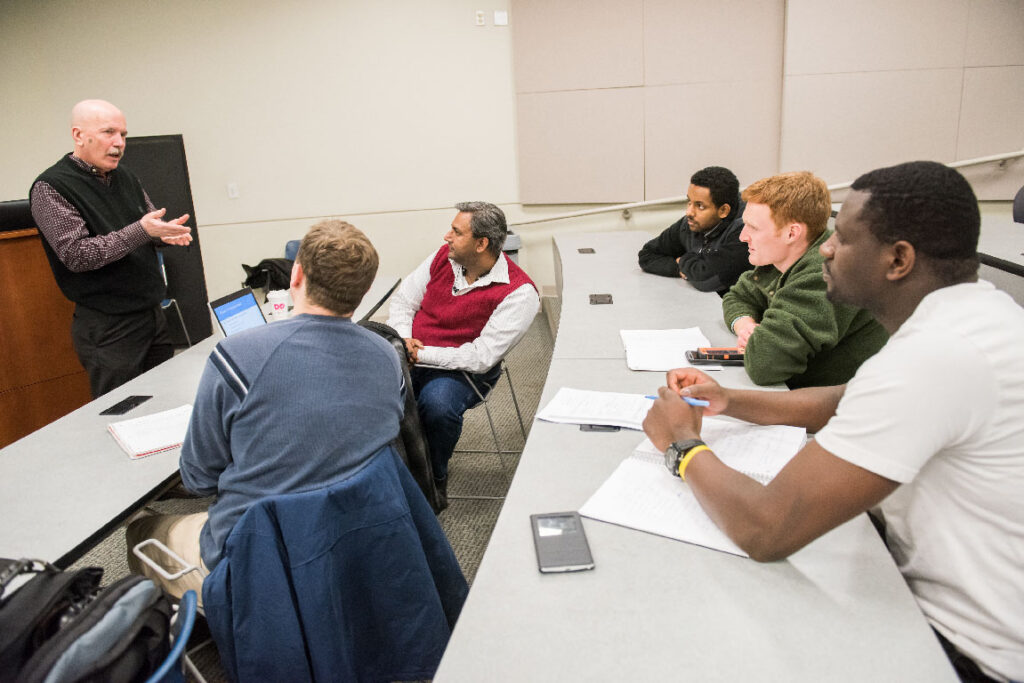 Professor speaking to small group of professional program students